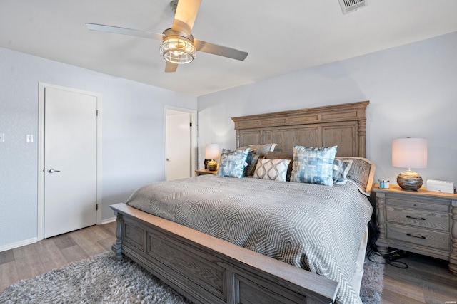 bedroom featuring light wood-style floors, visible vents, and a ceiling fan