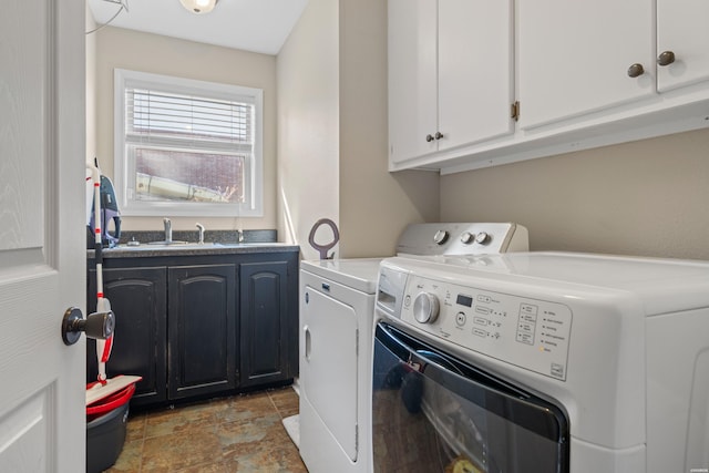 washroom with separate washer and dryer, cabinet space, stone finish flooring, and a sink