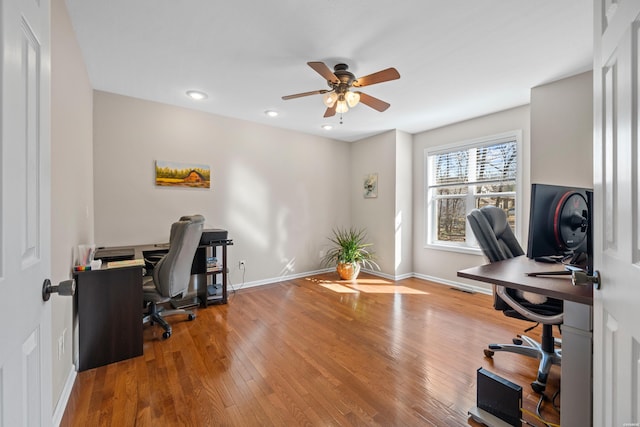 office space featuring a ceiling fan, baseboards, and wood finished floors
