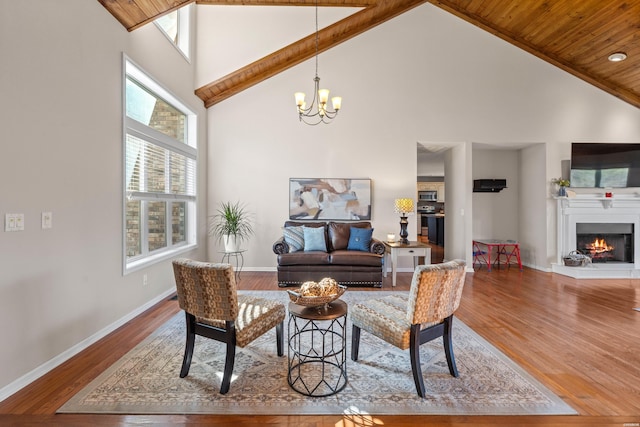 living area featuring a wealth of natural light, high vaulted ceiling, and wood finished floors