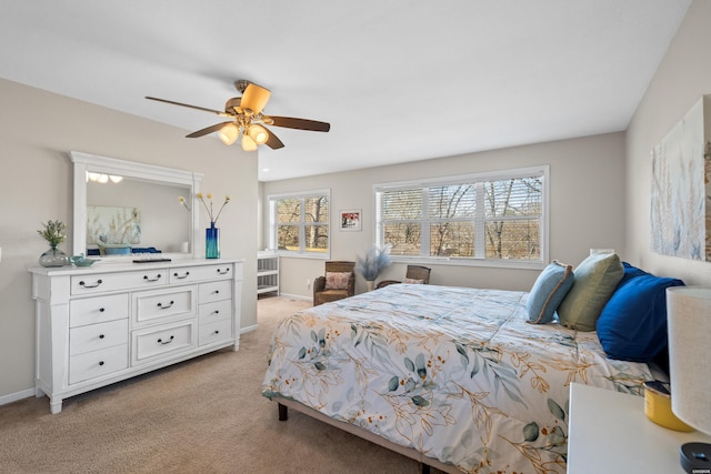 bedroom featuring light colored carpet, baseboards, and a ceiling fan