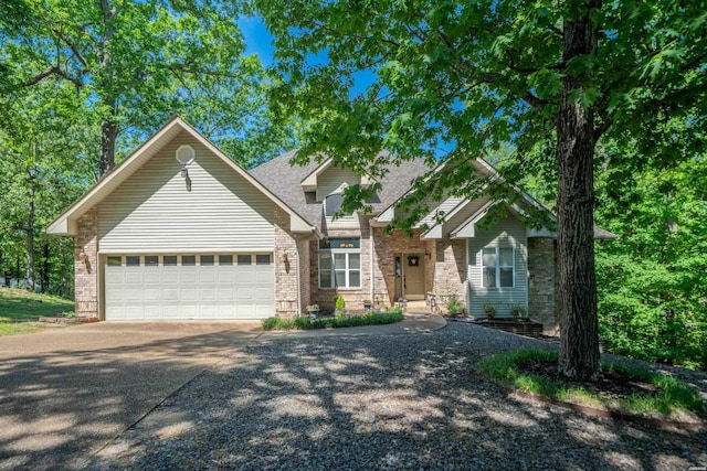 craftsman-style home featuring a garage, brick siding, and driveway