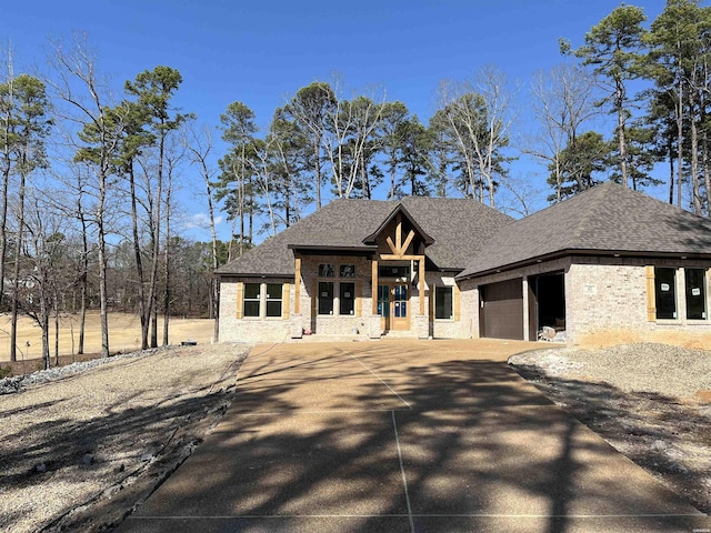 view of front of house featuring concrete driveway, roof with shingles, and an attached garage