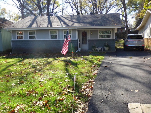 single story home with aphalt driveway, entry steps, brick siding, and a front yard