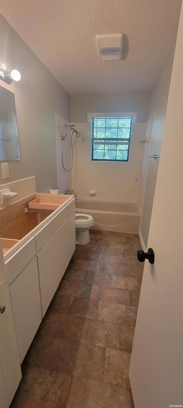 full bath with shower / bathtub combination, a textured ceiling, vanity, and toilet