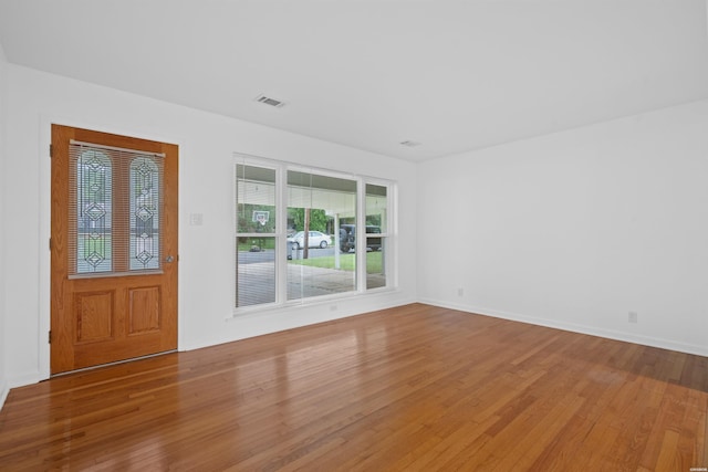 interior space with wood finished floors, visible vents, and baseboards