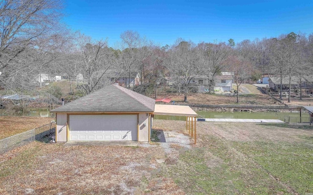 view of yard featuring a detached garage, an outdoor structure, and fence