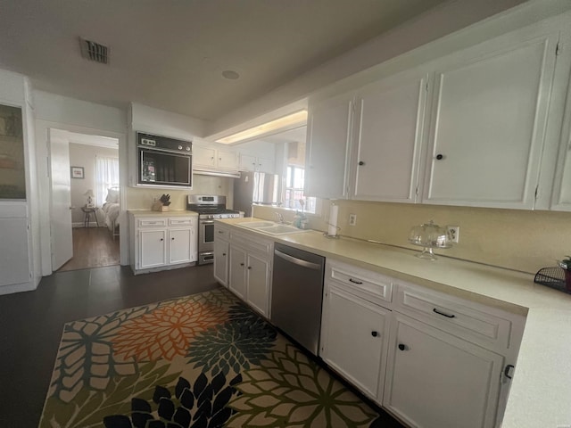 kitchen featuring light countertops, visible vents, appliances with stainless steel finishes, white cabinetry, and a sink