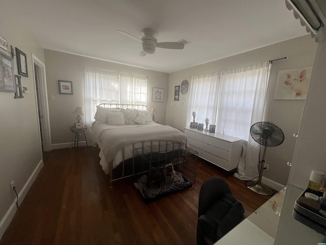 bedroom featuring a ceiling fan, visible vents, baseboards, and wood finished floors