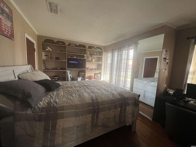 bedroom with a textured ceiling, visible vents, dark wood-type flooring, and crown molding