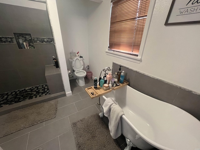 bathroom with tile patterned floors, a freestanding bath, toilet, and a walk in shower