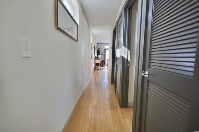 hall with light wood finished floors and baseboards