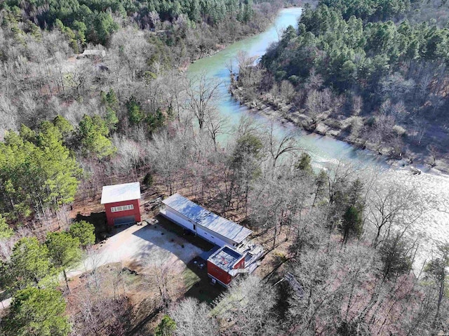 drone / aerial view featuring a forest view and a water view