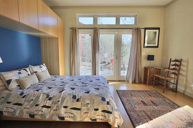 bedroom featuring light wood-type flooring and access to outside