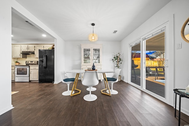 dining area featuring dark wood-style floors, visible vents, and baseboards