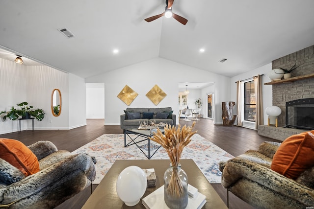 living room with lofted ceiling, a fireplace, visible vents, and dark wood finished floors