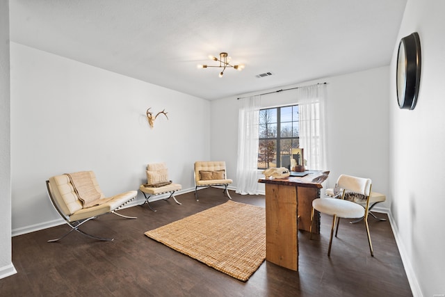 sitting room featuring dark wood-style flooring, visible vents, baseboards, and an inviting chandelier