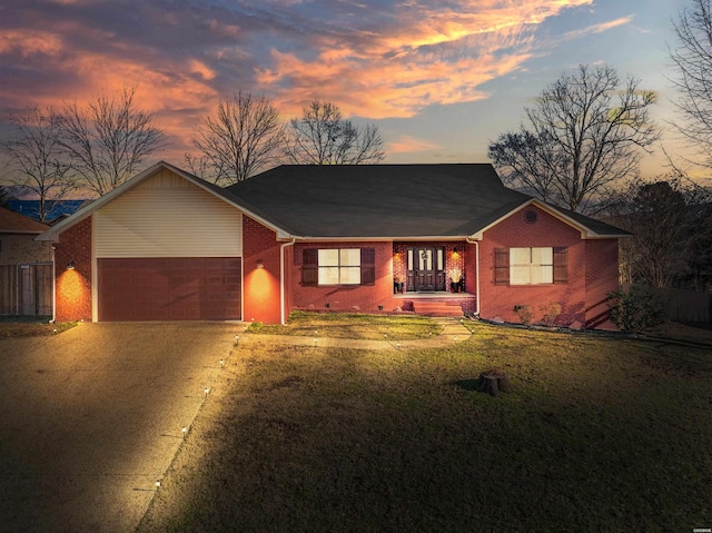 view of front of home featuring a garage, a front lawn, concrete driveway, and brick siding