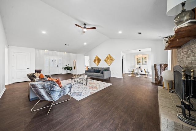 living area featuring baseboards, lofted ceiling, ceiling fan, dark wood-style flooring, and a brick fireplace