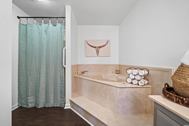 full bathroom with a bath and wood finished floors