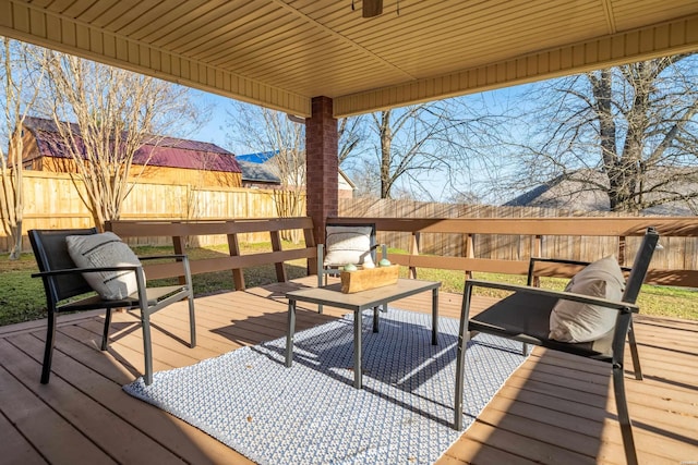 wooden deck with outdoor lounge area and a fenced backyard