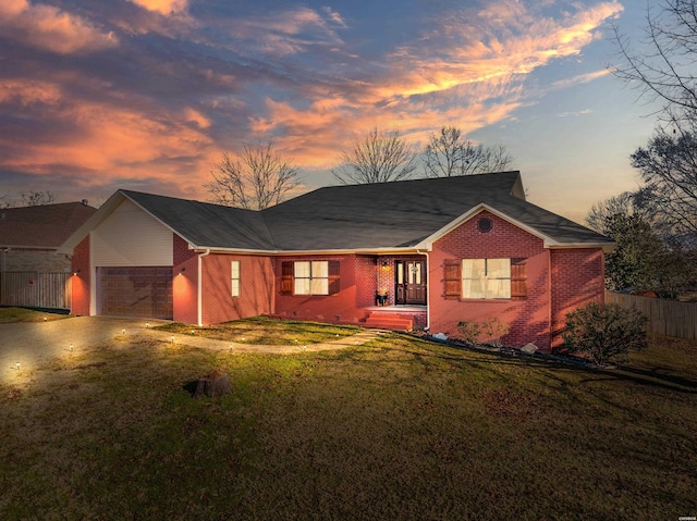 single story home featuring brick siding, a front yard, fence, a garage, and driveway