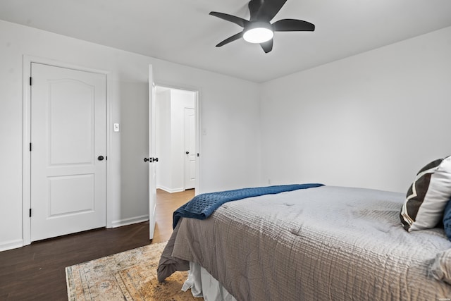 bedroom with dark wood finished floors, a ceiling fan, and baseboards