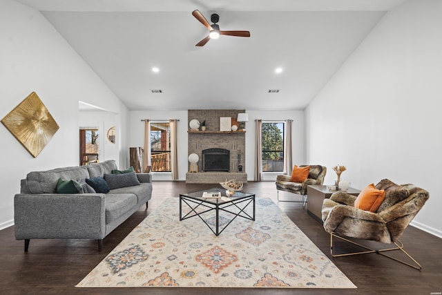 living area with a ceiling fan, a fireplace, visible vents, and dark wood-type flooring