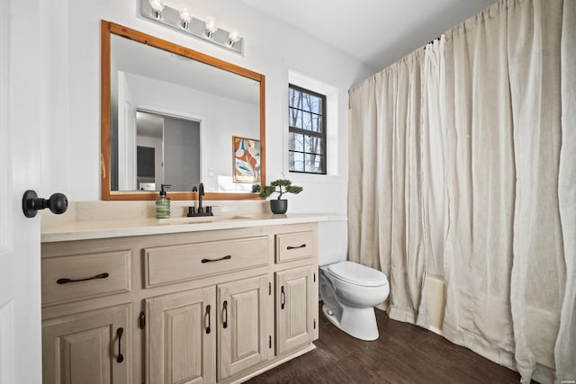 full bathroom featuring toilet, shower / tub combo with curtain, wood finished floors, and vanity