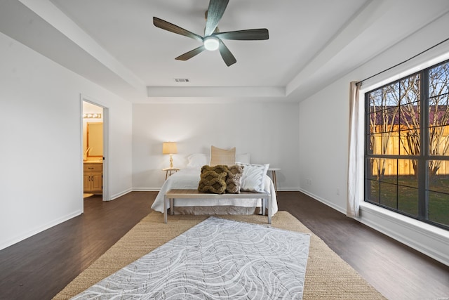 bedroom featuring ceiling fan, visible vents, baseboards, dark wood-style floors, and a raised ceiling