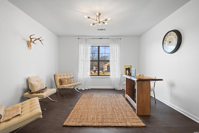 living area featuring dark wood-type flooring, a chandelier, visible vents, and baseboards