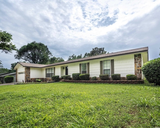 single story home featuring a garage, a front yard, and stone siding