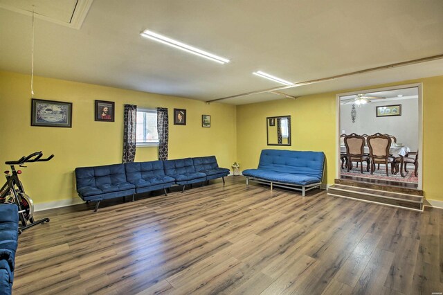 living room with attic access, baseboards, and wood finished floors