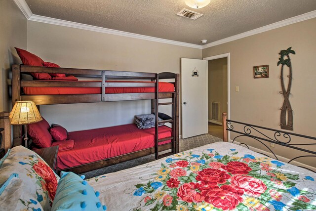 bedroom featuring visible vents, crown molding, and a textured ceiling