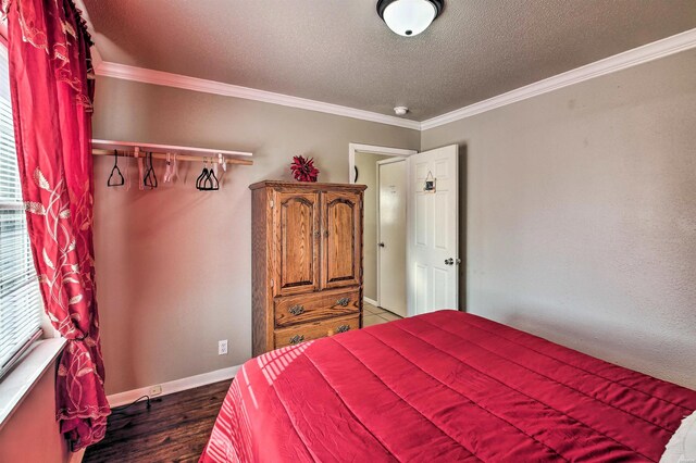 bedroom featuring baseboards, multiple windows, ornamental molding, and wood finished floors