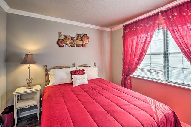 bedroom featuring ornamental molding, a textured ceiling, and wood finished floors