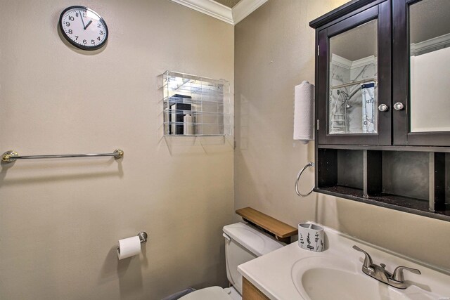 bathroom featuring toilet, ornamental molding, and vanity