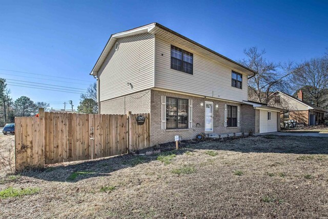 view of front of property with brick siding and fence