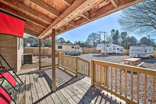 wooden terrace featuring cooling unit and a fenced backyard