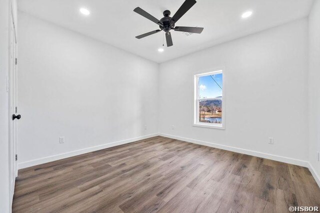 unfurnished room with baseboards, wood finished floors, and recessed lighting