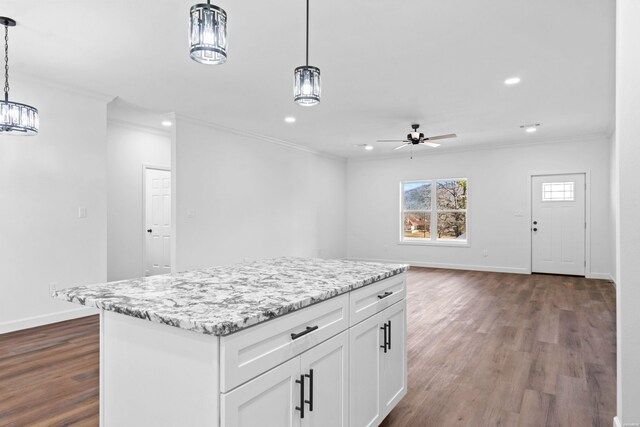 kitchen with a center island, white cabinetry, pendant lighting, and open floor plan