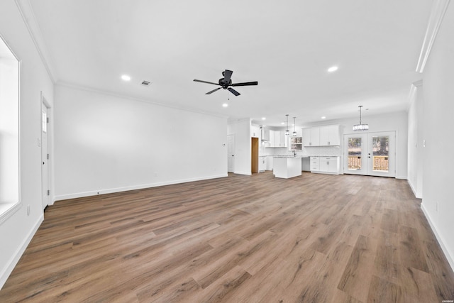 unfurnished living room with recessed lighting, visible vents, a ceiling fan, ornamental molding, and wood finished floors