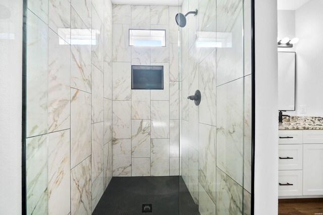 bathroom with a shower stall and vanity