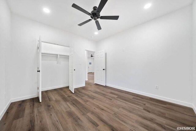 unfurnished bedroom with recessed lighting, a closet, dark wood finished floors, and baseboards