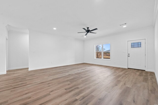 unfurnished living room with ceiling fan, visible vents, baseboards, light wood finished floors, and crown molding