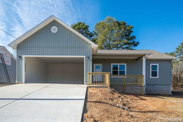 ranch-style home featuring a shingled roof, covered porch, an attached garage, and concrete driveway