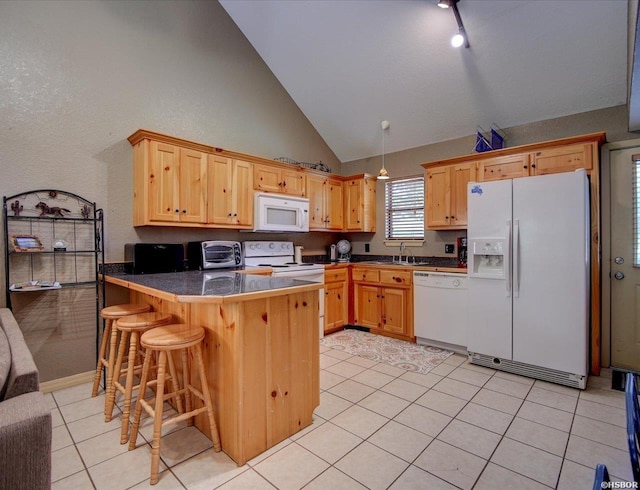 kitchen featuring a peninsula, white appliances, a sink, a kitchen breakfast bar, and open floor plan