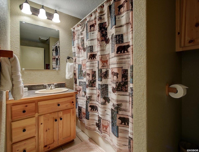 bathroom featuring a textured ceiling, a textured wall, tile patterned flooring, vanity, and shower / bathtub combination with curtain