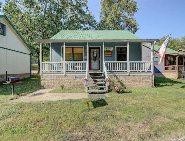 bungalow-style house with a porch, a front yard, and metal roof