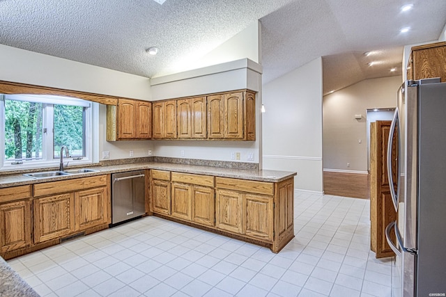 kitchen with brown cabinets, a sink, light tile patterned floors, vaulted ceiling, and stainless steel appliances